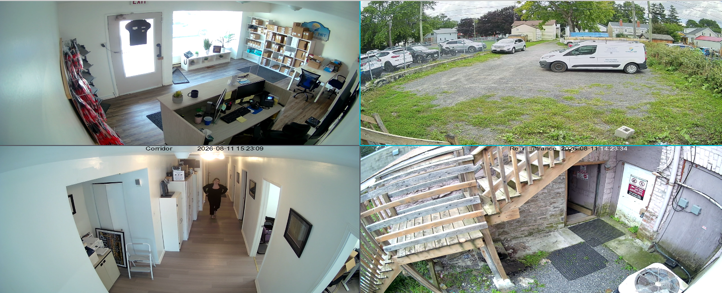 AiBase quad-camera view at 2:23 PM, midday, showing full colour footage of an office, parking lot, corridor, and rear entrance